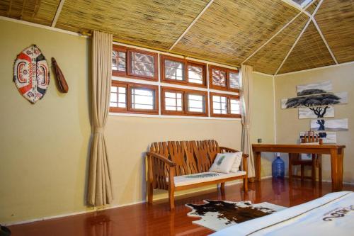 a room with a chair and a table and a window at Mara Chui Eco-Resort in Sekenani