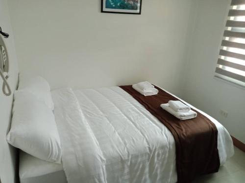a bedroom with a bed with two towels on it at The Wharf Transient Hotel in Batangas City