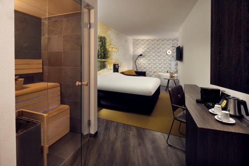 a hotel room with a bed and a bathroom at Inntel Hotels Amsterdam Centre in Amsterdam