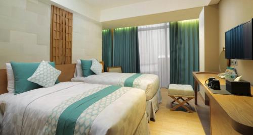 Una cama o camas en una habitación de Bedrock Hotel Kuta
