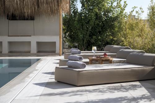 a patio with a couch and chairs next to a pool at Bianco Villa - Adam in Pefki