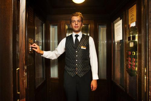 a man in a vest and tie holding a gun at Hestia Hotel Barons Old Town in Tallinn