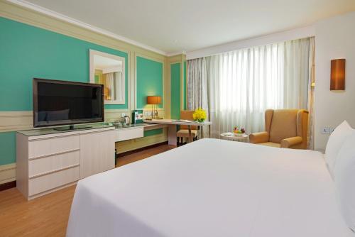 a hotel room with a bed and a flat screen tv at Windsor Plaza Hotel in Ho Chi Minh City