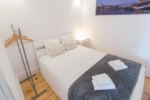 ポルトにあるSmooth Oporto Apartment by Porto City Hostsのベッドルーム1室(白いベッド1台、タオル2枚付)