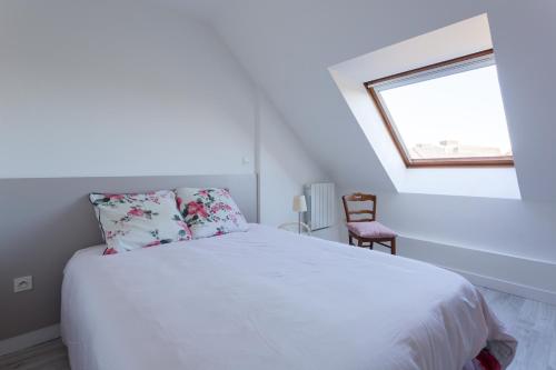 a bedroom with a white bed and a window at Le Mancini - Parking et Terrasse in Mayenne