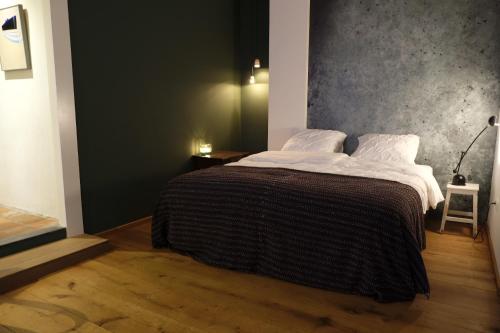 1 dormitorio con 1 cama grande con sábanas blancas en B&B Radijs, en Beegden