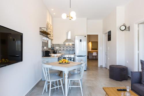 una cucina e un soggiorno con tavolo e sedie di Panorama Luxury Rooms a Spílion