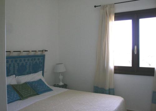 a bedroom with a bed and a window at Casa Bithia in Chia