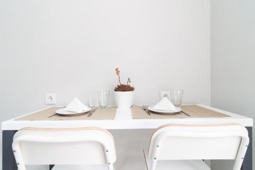 a white table with two white chairs and a table with glasses at Villa Ponta do Sol Apartment in Ponta do Sol