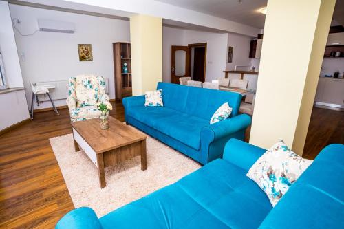 sala de estar con sofá azul y mesa en Old City Square Apartment, en Lovech