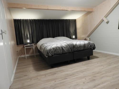 een slaapkamer met een bed en een raam in een kamer bij ut Boshuuske in Lottum
