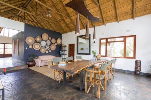 a living room with a large wooden table and chairs at Ku Sungula Safari Lodge in Balule Game Reserve