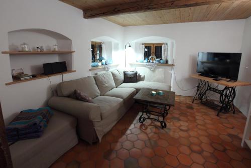 a living room with a couch and a tv at Ferienhaus Tölzer Land in Bad Tölz