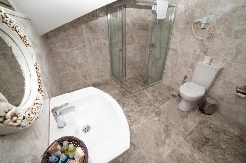 
a bathroom with a toilet, sink, and shower stall at HHK Hotel Downtown in Istanbul
