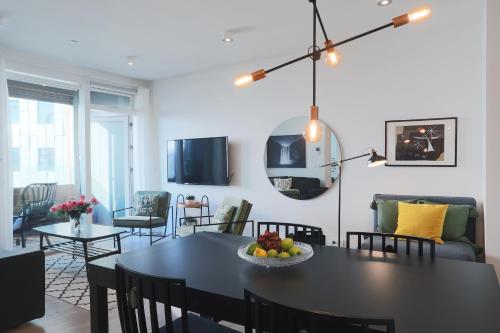 uma sala de jantar e sala de estar com uma mesa preta e cadeiras em Salka Suites Luxury apartment 2BR, 2 bathrooms em Reykjavík