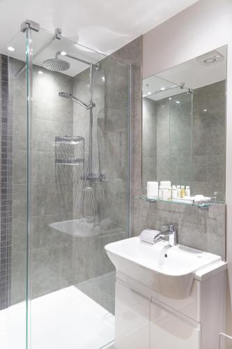 a bathroom with a sink and a glass shower at Citystay Living - Hinton House in Cambridge