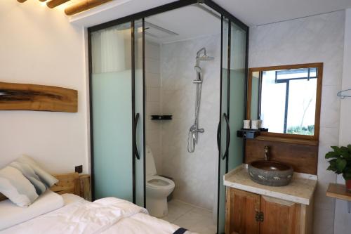 a bathroom with a shower and a toilet and a sink at Eastwood Inn Xi'an in Xi'an