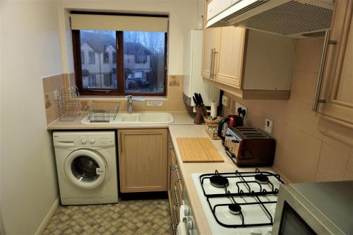 a kitchen with a washing machine and a sink at Palmer's Apartment in Bristol