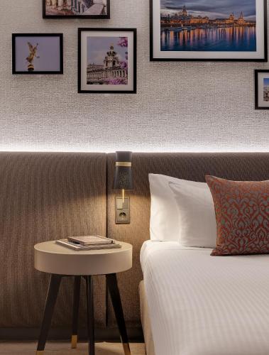a hotel room with a bed and a side table at Bilderberg Bellevue Hotel Dresden in Dresden