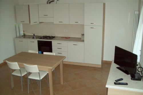 a kitchen with a wooden table and white cabinets at Apartment Maria in Brenzone sul Garda