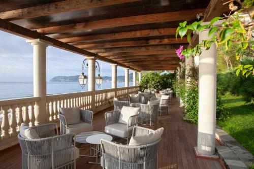 una terraza con sillas y mesas y el océano en Diana Grand Hotel, en Alassio