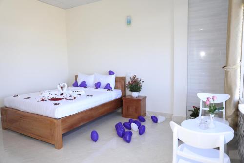 a bedroom with a bed with purple petals on the floor at Da Lat Ngoi Sao Viet in Da Lat