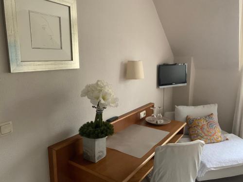 a hotel room with a table with a vase of flowers on it at Lindenhof in Hainburg
