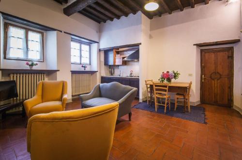 a living room with two chairs and a table at Castello di Volpaia in Radda in Chianti