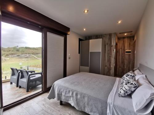 een slaapkamer met een bed en een groot glazen raam bij Caracola de Cabo Home in Hio