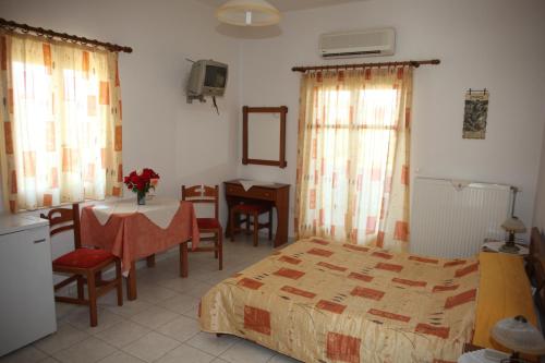 - une chambre avec un lit, une table et un bureau dans l'établissement Studios Marianna, à Skiros