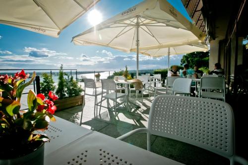 a patio with white chairs and tables and umbrellas at Hotel Starzyński in Płock