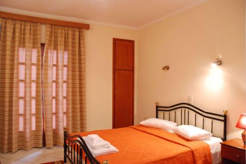 una camera con un letto arancione e una finestra di Sfaragoulias Inn a Kalavrita