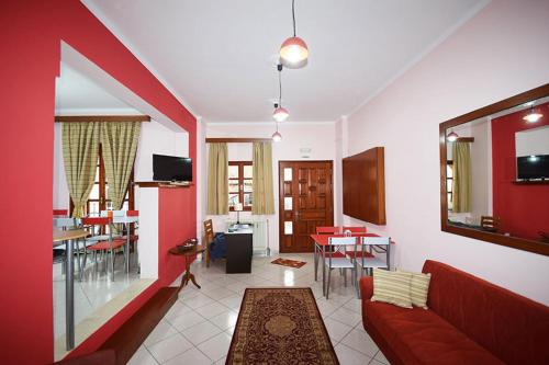 sala de estar con sofá rojo y comedor en Sfaragoulias Inn en Kalavrita