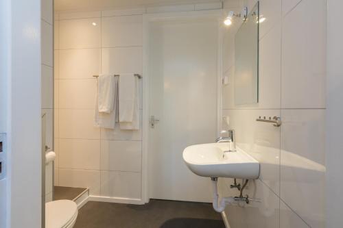 a bathroom with a sink and a toilet and a shower at Welcome in - Vakantiehuis 6 en 12 personen, Vroondijk in Vrouwenpolder in Vrouwenpolder