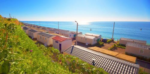 a row of houses on a hill next to the ocean at Atlantica Parc in Taghazout