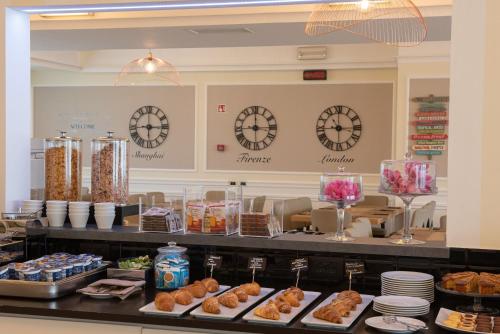 a buffet line with pastries and clocks on the wall at JR Hotels Gigli Firenze in Calenzano