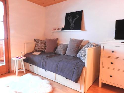 1 dormitorio pequeño con 1 cama con mantas y almohadas azules en Krähenberg am Rande der Wildnis en Sibratsgfäll