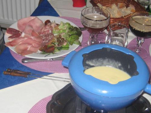 a table with a blue bowl of sauce and a plate of food at Auberge Hôtel chambre Tout Confort B-B et Restaurant Les Colombes in Sugny