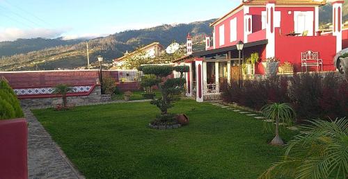 ein Haus mit einem Garten mit grünem Gras in der Unterkunft the old school in Calheta