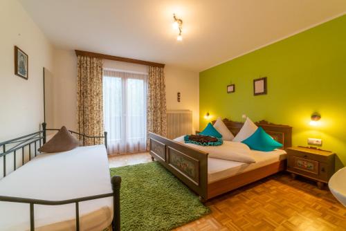 a bedroom with two beds and a green wall at Haus Netzer Anita in Schruns