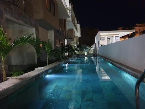 a swimming pool in a house at night at Westwood Luxury Penthouse with private Roof top Ref 15847 in Flic-en-Flac