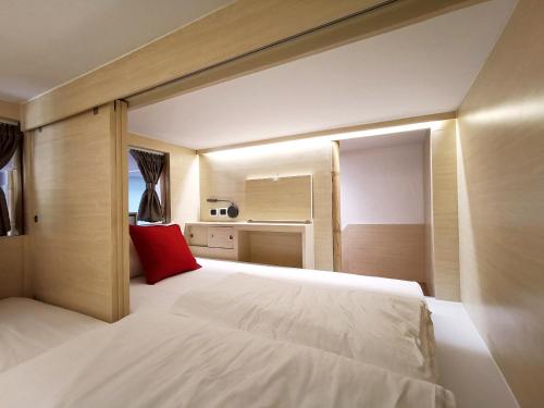 a bedroom with a large white bed with a red pillow at Pannana Cha-am in Cha Am