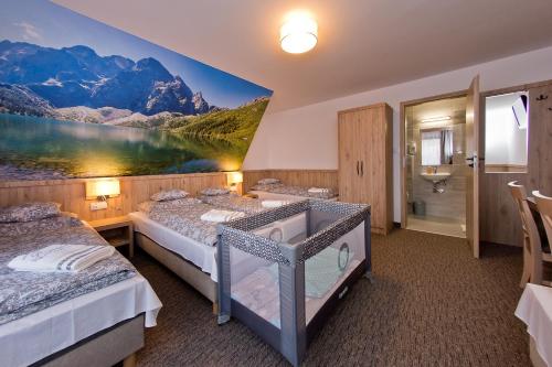 two beds in a room with a painting on the wall at Pokoje Gościnne Kornelia- Jacuzzi, sauna ! in Biały Dunajec