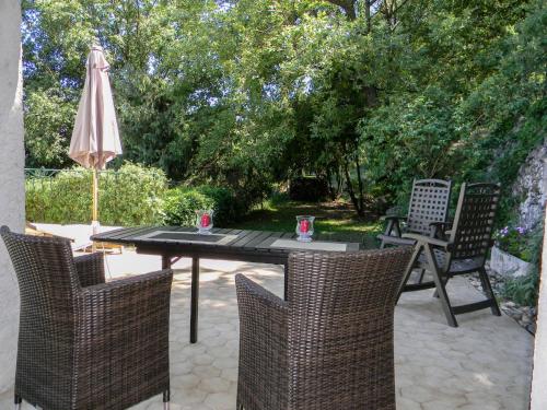 un patio con mesa, sillas y sombrilla en Apartment La Bachasse by Interhome, en Carros