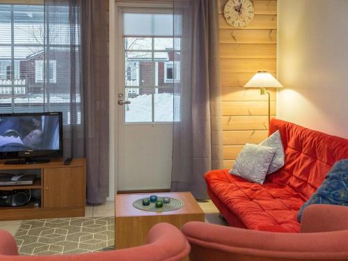 een woonkamer met een rode bank en een tv bij Holiday Home Karitahko a 7 by Interhome in Tahkovuori
