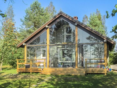 uma pequena casa com janelas de vidro na relva em Holiday Home Tuulikannel by Interhome em Hillilä