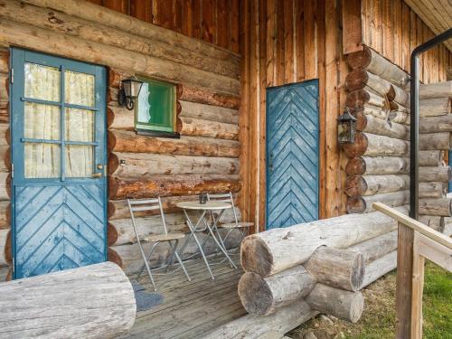 a log cabin with a blue door and a table at Holiday Home Vuokatinportti a 11 by Interhome in Lahdenperä