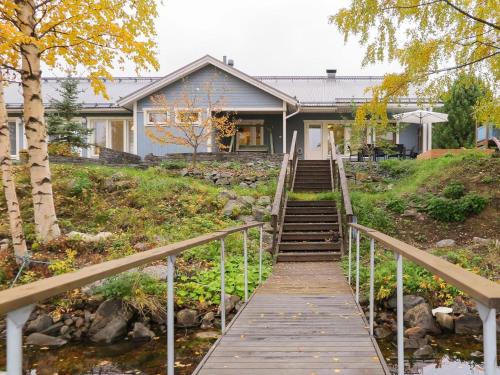 una casa con una pasarela de madera que conduce a ella en Holiday Home Villa lehmus by Interhome en Rovaniemi