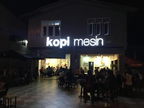 a group of people sitting at a restaurant at night at CMK APARTMEN MUTIARA TOWER 3 BEDROOM KOTA BHARU#Netflix in Kota Bharu