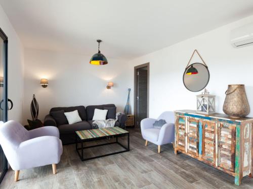 uma sala de estar com um sofá, cadeiras e uma mesa em Apartment Le Palazzu-10 by Interhome em Porto-Vecchio